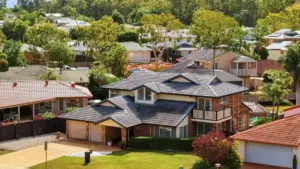 Rental returns in South East Queensland — aerial view of a two-storey brick home in a leafy Brisbane suburb